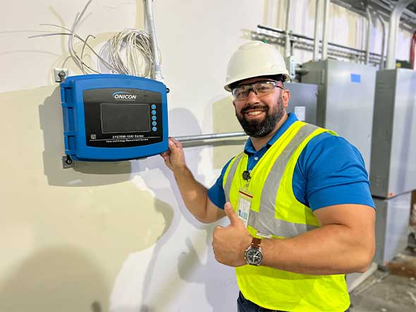 smiling installation technician with Onicron meter